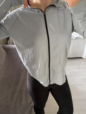 Ljusgrå sportjacka/tröja - Säljer en ljusgrå sportjacka med luva, vet inte vart ifrån eller hur stor den är.             Men artikelnummret finns med på en bild. Känns som att tröjan är i storlek M, och den har väldigt tunt och mjukt material.  Hör gärna av dig om du undrar något!