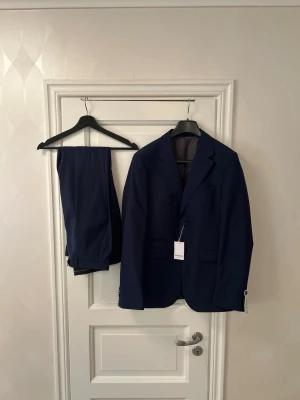 Oanvänd White Bros kostym 50 marinblå nypris 4000 kr - Säljer en elegant marinblå kostym från White Bros.  Nypris: 4 000 kr Mitt pris: 1 595 kr  Helt ny och oanvänd, i perfekt skick. Storlek: 50  Tidlös modell – passar student, bröllop, bal, examen och jobb. Klassisk marinblå färg som alltid fungerar.  Kan fraktas eller provas i Sollentuna. Fler kostymer finns i andra storlekar och märken. Hör av dig vid intresse!