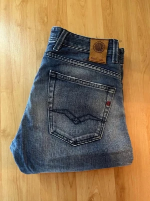 Replay Jeans - Snygga Repaly Jeto jeans i blått med kontrastmönster. Midja 39cm, längd 107cm. Obs jeansen har en defekt - se bild. JAG SKICKAR EJ FLER BILDER NÄR JAG BÄR JEANSEN! för bättre inblick i passformen rekommenderar jag att googla på modellnamnet. För storleksguide kolla måtten noggrant då jeansen alltid kan vara uppsydda heller krympta och jag ej tar emot returer :) 1,39