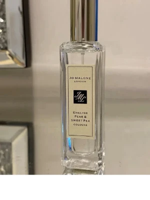 Jo Malone English Pear & Sweet Pea 30 ml - Fräsch parfym från Jo Malone i doften English Pear & Sweet Pea 30 ml. Endast testad. Flaskan är genomskinlig med en elegant silverfärgad kork och klassisk etikett. Perfekt för dig som gillar fruktiga och blommiga toner.