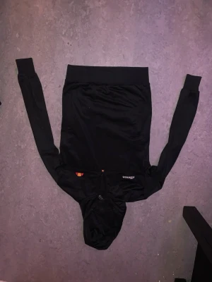Svart hoodie från Ellesse - Säljer en svart hoodie från Ellesse med huva och långa ärmar. Hoodien har ett diskret Ellesse-tryck på bröstet och ribbade muddar vid ärmslut och nederkant. Perfekt för dig som gillar sportig och avslappnad stil.