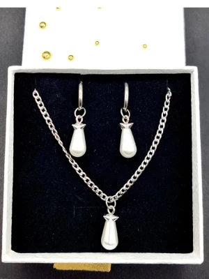 Smyckesetet  - Smyckesetet påminner om Maria Nilsdotter. Material-rostfritt stål. Örhängen längd-3,7cm, halsband längd-40cm. Vid köp berlocker som kan bytas ut, Se ingår tvā extra själva hänget är ömtåligt och känsligt för stötar.