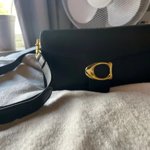 Svart axelväska från Coach i skinn - Snygg svart axelväska från Coach i äkta skinn med grov struktur. Helt ny och aldrig använd💕