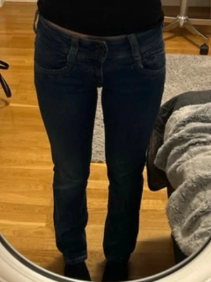 Lågmidjade mörkblå jeans från Pepe Jeans - Säljer ett par mörkblå jeans från Pepe Jeans London med klassisk femficksmodell och raka/lätt utsvängda ben. Jeansen har snygga kontrastsömmar och bakfickor och en läderpatch bak i midjan.  Tillverkade i slitstark denim, perfekta för en avslappnad och stilren look. Storlek 26/30💕Är öppen för förhandling om pris 