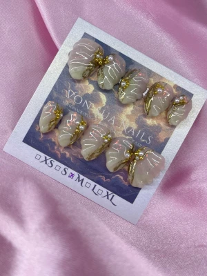 Shelluxe (M);Short Almond - Snygga handgjorda press-on naglar i en ljus nudebeige, med ljusgröna toppar nyans med guldiga detaljer, 3D linjer och små pärlor. Naglarna har en kortalmond-form och är handgjorda med exklusiv design som verkligen sticker ut.M: 16 mm, 12 mm, 12,5 mm, 11,5 mm, 10 mm