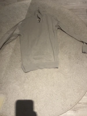 Beige halvzip tröja Jack & Jones - Snygg beige stickad tröja från Jack & Jones med halv dragkedja vid halsen. Tröjan har långa ärmar och ribbade muddar vid ärmslut och nederkant. Perfekt för lager på lager och enkel att matcha med jeans eller chinos.