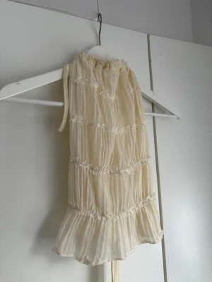 Krämfärgat volang nattlinne - Säljer en superfin beige topp med volanger och spetsdetaljer. Toppen är ärmlös med tunna band. Toppen är från Shein 
