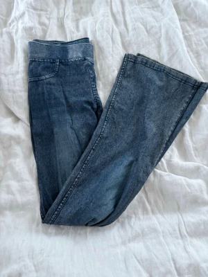 Blå bootcut tagits  - Säljer ett par blå bootcut stretch tagits med hög midja och klassisk femficksdesign. Tagitsen har en snygg tvättad look och är tillverkade i ett mjukt denimtyg som ger en skön passform. Perfekta för dig som gillar retrostil och vill ha ett par sköna byxor med  jeanslook.💙💙