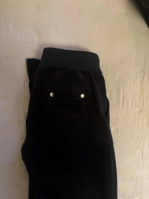 Svarta Juicy Couture byxor - Mörka svarta mjukisbyxor i velour från Juicy Couture. Knappt använda och passar mig som är 170! 