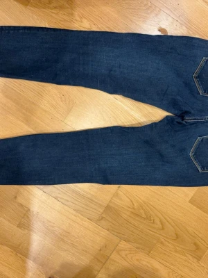 Mörkblå skinny jeans från Replay - Snygga mörkblå skinny jeans från Replay med klassiska fem fickor och gul kontrastsöm. Jeansen har normal midja och är tillverkade i stretchigt denim för en bekväm passform. Perfekta till en avslappnad stil. Priset inte hugget i sten 
