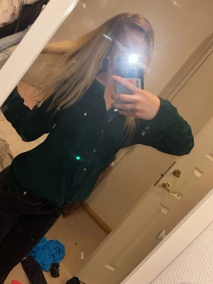 Mörkgrön skjorta med knappar - Snygg mörkgrön skjorta med klassisk krage och knappar framtill. Skjortan har lång ärm och en rak passform som passar till det mesta. Perfekt för dig som vill ha en stilren och enkel look.