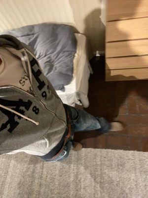 Abercrombie & Fitch Hoodie - Snygg grå zip-hoodie från Abercrombie & Fitch med mörkblå tryckdetaljer och texten 'A&F 1892' på bröstet. Den är i storlek xs men den passar mig som är 183 helt perfekt. Perfekt för en avslappnad och cool stil. Undrar du något är det bara att skriva🙌