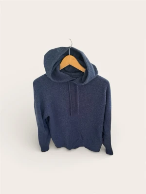 Soft Goat Hoodie – 100% Kashmir – Washed Blue (Slutsåld!) - Säljer en fantastisk kashmir-hoodie från Soft Goat i den eftertraktade (och slutsålda) färgen Washed Blue. Detta är en otroligt snygg, melerad blå nyans som ger en avslappnad men exklusiv look. Modellen är en klassisk hoodie utan dragkedja med snörning i luvan.  Tillverkad i 100% mjuk kashmir. Perfekt att bära direkt mot huden då den inte kliar det minsta.  Skick: Extremt bra skick! Endast använd vid enstaka tillfällen.  Storlek: Small (S). Nypris: 4000 kr.