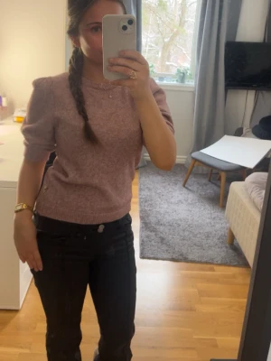 Ljusrosa stickad tröja med puffärm från Pomp de Lux - Säljer en ljusrosa stickad tröja med korta puffärmar och rund halsringning. Tröjan har ribbstickade muddar vid ärmslut och nederkant. Perfekt för dig som gillar en söt och trendig look. Storleken är 146/152 men passar om en XS 💗