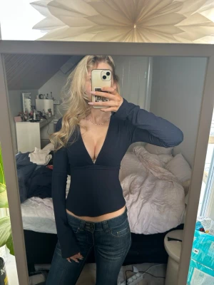 Långärmad topp - Jättefin mörkblå topp från Nelly, man kan välja om man vill knyta snörena fram eller bak❣️ Endast använd någon gång, den har fått ett litet hål i sömnen på armen, annars jättefint skick