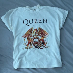 Queen tröja - En tröja med bandet Queen. Mycket bra skick förutom en liten fläck på baksidan (bild 4). Fläckarna som syns på några av bilderna är bara vatten från att ha strykt tröjan