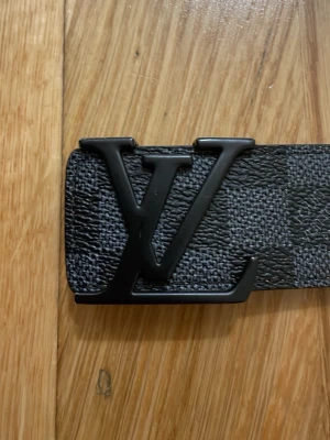 Svart rutigt bälte  - Säljer ett snyggt svart rutigt bälte med svart spänne man får med allt som är på bilden inklusive låda, kvitto och certifikat