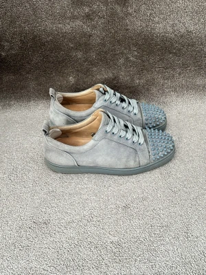 Christian Louboutin skor  - Hej! Säljer dessa riktigt feta ljusgrå Christian Louboutin skor! Skorna är i ett bra skick som visas på bilderna och endast 1 nit är borta (enkelt att skaffa en ny). Helt nya Christian Louboutin snören sitter i och som tillbehör får du påsen till snörena samt en dustbag! Skorna har vårdats med 2 st heel patches i hälen för extra comfort och skorna har limmats vid flärpen längst bak (bild 4). Nypris: 10000kr! Skriv vid minsta intresse av köp 😊mvh DS 