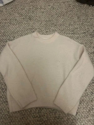 Ljusbeige stickad tröja från Vailent - Mysig ljusbeige stickad tröja från Vailent med rund halsringning och ribbade muddar vid ärmslut och nederkant. Perfekt för lager-på-lager och enkel att matcha med olika outfits.