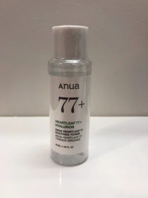 Anua Heartleaf 77+ Hyaluron Toner - En genomskinlig toner från Anua med Heartleaf 77+ och hyaluron. Kommer i en liten plastflaska med vit etikett och svart text. Perfekt för att återfukta och lugna huden. Innehåller 40 ml.