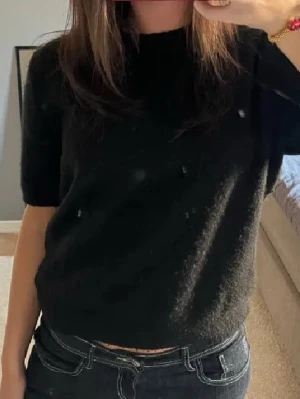 Svart stickad kortärmad tröja - den första bilden är inte min. Skulle även säga Xs