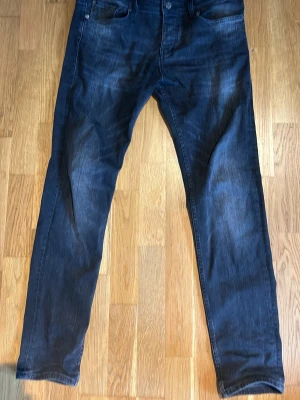 Gråa  jeans från BOSS - Snygga gråa  jeans från BOSS med klassisk femficksmodell och raka ben. Jeansen har en diskret tvättad look och är tillverkade i ett mjukt denimtyg som ger en bekväm känsla. Perfekta för dig som gillar stilrena och tidlösa jeans.