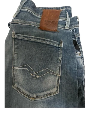 Replay blåa jeans med slitningar - Blåa Klassiska Replay Hyperflex i ett bra skick med slitningar. Snygga och bekväma jeans med stretch för bra passform i storlek 32/32. Hör av er vid minsta fundering 
