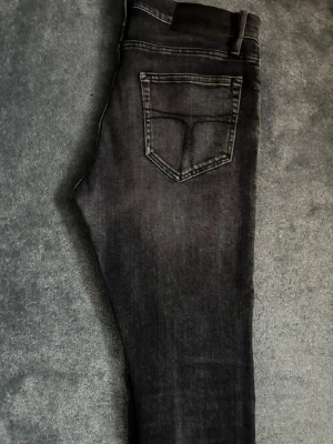 Svarta slim jeans från tiger of Sweden - Säljer ett par svarta slim fit jeans från tiger of Sweden framtill samt en snygg tvättad look. Perfekta till en avslappnad stil och passar till det mesta. Priser är diskutersbart och jag skickar samma dag 