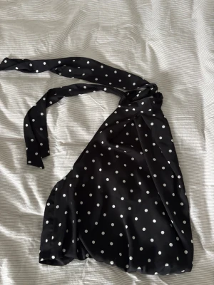 Prickig svart halterneck topp - Snygg svart halterneck topp från h&m som aldrig har kommit till användning. Toppen har knytning i nacken och öppen rygg. 🖤🤍