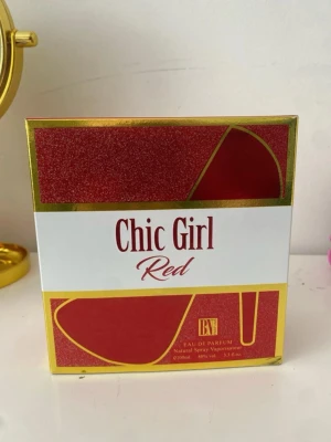 Chic Girl Red parfym 100ml - Chic Girl Red är en Eau de Parfum i en snygg röd och guld kartong med glittriga detaljer. Förpackningen har en modern design med högklackad sko som motiv. Innehåller 100 ml naturlig spray. Perfekt för dig som gillar trendiga och feminina dofter. Helt ny utan prislapp