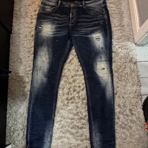 Mörkblå  jeans Alessandro Zavetti - Snygga mörkblå skinny jeans från Alessandro Zavetti med slitna detaljer och ljusa partier framtill. Jeansen har klassisk femficksdesign, dragkedjegylf och coola slitningar för en trendig look. Perfekta för dig som gillar streetstyle.