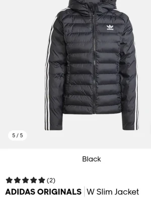 Svart pufferjacka från Adidas Originals - Svart vårjacka med slim fit från Adidas Originals, (ord.pris 1199kr) Jackan har huva, dragkedja framtill och klassiska vita ränder längs ärmarna. Materialet är glansigt och quiltat, perfekt för kalla vår/sommardagar. Adidas-loggan är broderad på bröstet. Helt ny, använd endast en gång. Riktigt snygg och stilren adidas jacka som tyvärr var för liten för mig & kunde inte bytas då jag redan tagit av lapparna.