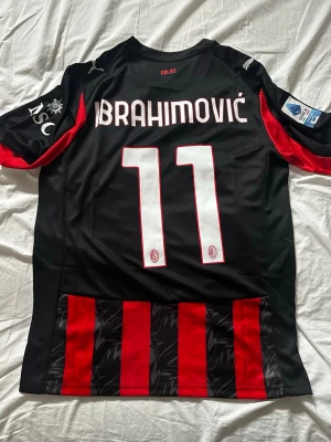 Ac milans hemmatröja 25/26, Ibrahimović nr 11 - Ac milans officiella hemmatröja 25/26 med Ibrahimović nummer 11 på ryggen. Tröjan är från Puma och har serie A loggan på axeln. Storlek M.