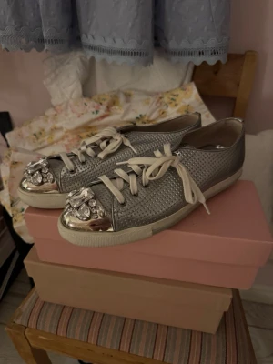 Silvriga sneakers  från Miu Miu - Säljer dessa supersnygga sneakers i från Miu Miu då det inte kommer till användning🌸🎀 stl 40, men passar mig som har stl 39 med en extra sula❣️ dom är i bra skick🌸🎀❣️priset är diskuterbart☺️