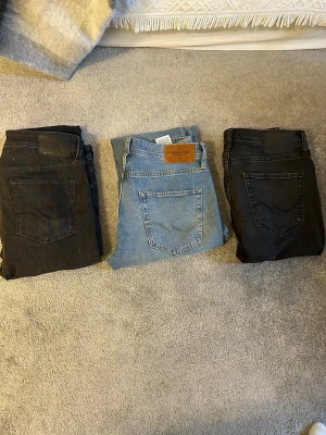 3-pack jeans i olika färger - Säljer tre par jeans från Jack & Jones: ett par svart, ett par ljusblå och ett par mörkgrå. Alla har klassisk femficksdesign och slim och lite vidare ben. Perfekta för dig som vill ha olika färger att variera mellan. Materialet är mjukt denim som sitter skönt hela dagen. I storlek 30/31 och 32/32.