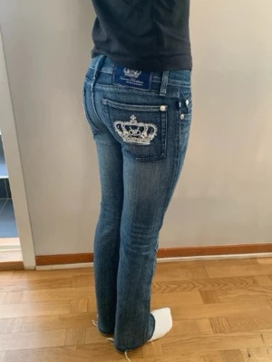 Vicktoria Beckham bootcut jeans - Super snygga Vicktoria Beckham jeans. Det är mörkblåa och är low waist bootcut. På fickornq är det fina kronors som är vita. Det är tyvärr för små för mig men waist är 37 cm och innebenslängden är 75-76 cm!💕