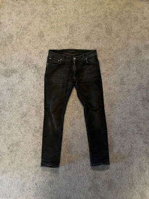 Nudie jeans skinny lin worn black - Säljer ett par svarta slim fit jeans från Nudie Jeans med klassisk femficksmodell och diskreta slitningar. Jeansen har smal passform, normal midja och är tillverkade i stretchigt denimtyg för extra komfort. Storlek W30 L28. Hör av er vid fler funderingar✅