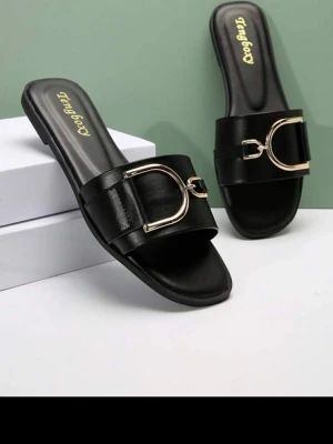 Svarta sandaler med gulddetalj - Stilrena svarta sandaler från Tangboy med bred rem och snygg guldfärgad metallspänne framtill. Platt sula och öppen tå ger en modern look. Tillverkade i konstläder för en trendig och bekväm känsla. Beställde i storlek 37or. Men de var för små. De är egentligen storlek 36or. Helt Nya, oanvända. 