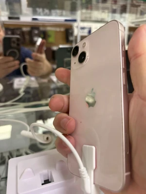 Ljusrosa iPhone med dubbla kameror - Snygg ljusrosa iPhone från Apple med två kameror på baksidan och platt aluminiumram. Mobilen har en stilren design med glasbaksida och tydlig Apple-logga. Perfekt för dig som vill ha en modern och trendig smartphone.