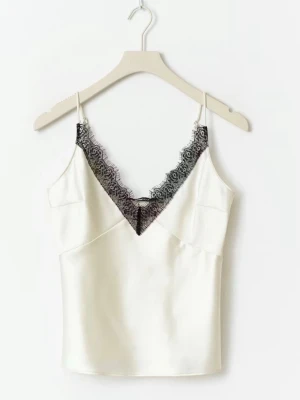 Spets linne - Snygg vit linnetopp med smala axelband och djup v-ringning dekorerad med svart spets. 
