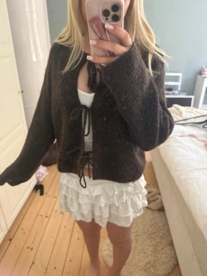 Brun stickad kofta med knytband - Fin stickad brun tröja med knytband. Jättefin men säljer pga att jag inte tycker att den sitter bra på mig använd fåtal gånger 