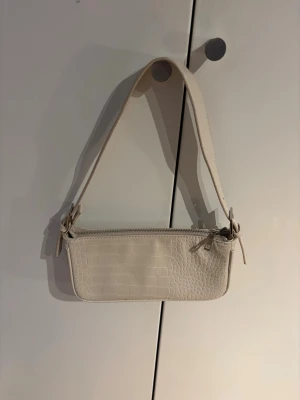 Beige axelväska med croco-mönster - Snygg beige handväska med croco-mönster och bred axelrem. Säljer den för den ej kommer till användning🤗