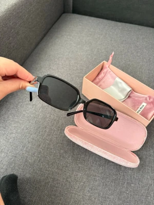Svarta solglasögon från Miu Miu - Snygga svarta solglasögon  med rektangular form