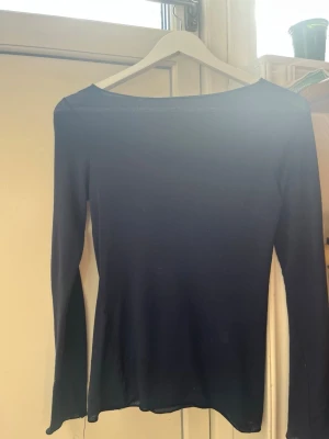 Mörkblå långärmad topp Intimissimi - Säljer en mörkblå långärmad topp från Intimissimi i ultralätt material med kashmir. Enkel och stilren design med rund halsringning och tight passform. Perfekt att styla till jeans eller kjol för en clean look.