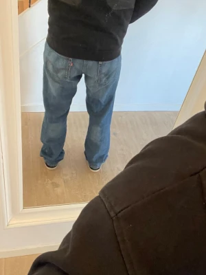 Blå bootcut jeans från Levi's - Säljer ett par klassiska blå jeans från Levi's med bootcut passform och normal midja. Jeansen har fem fickor och en snygg tvättad look. Perfekta till vardags och passar till det mesta. Tillverkade i slitstarkt denimtyg.