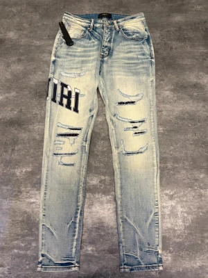 Ljusa slitna jeans från AMIRI - Säljer ett par ljusa blå jeans från AMIRI.