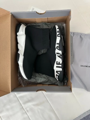Balenciaga Speed Trainer svarta sneakers - Svarta Balenciaga Speed Trainer sneakers med vit chunky sula och stor logotyp längs sidan. Stickad strumpdesign som sitter tight runt foten och ger en futuristisk vibe. Tillverkade i textil med gummisula för maxad komfort och stil.