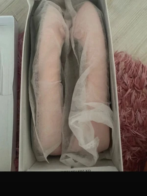 Ljusa rosa ballerinaskor med rosett - Säljer ett par ljusrosa ballerinaskor med söt rosett framtill. Skorna har en klassisk rundad tå och är tillverkade i ett slätt material som ger en stilren look. Är liten i storleken.