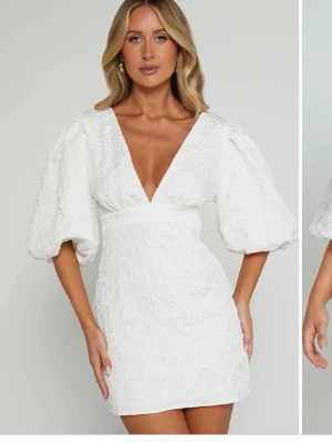 Vit kort klänning med puffärm - Showpo klänning perfekt till studenten. Har självt använt den en gång på utspringet så den är inform skick. Lite fläckig på insidan men det är inget som syns. Storlek 38 men den är lite insyd uppe vid axlarna då urringningen var väldigt djup. Har inte tvättat den men en tvätt så är säkert fläckarna på insidan borta! 