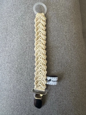 Virkad napphållare  - Virkad, beige napphållare, virkad av mig i 100% bomullsgarn med metallclips och silikonring.  Mönsterskapare: animo.design